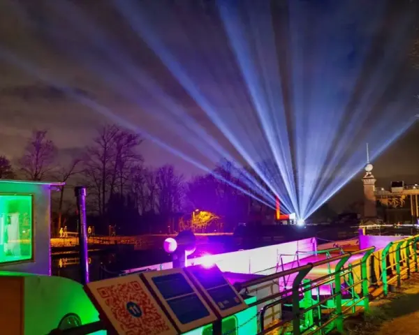 Lichterzauber am weihnachtsmarkt schiffshebewerk henrichenburg. Strahlende Lichtkegel erhellen den Nachthimmel über dem beleuchteten Schiffshebewerk.