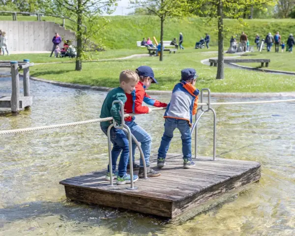 Drei Jungen auf einem Floß im Wasserpark am Schiffshebewerk Henrichenburg. Ein Spielplatz für kleine Abenteurer.