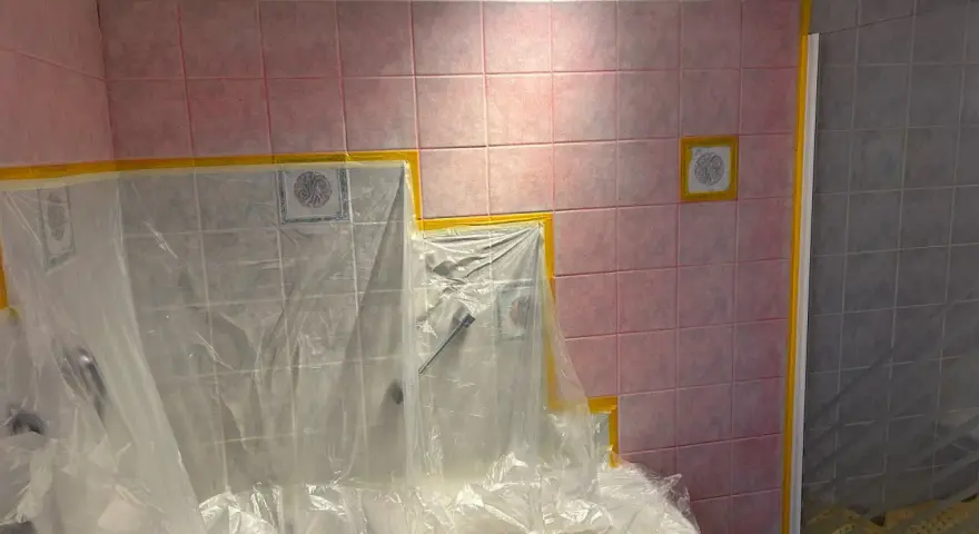 Badezimmerfliesen werden für das Streichen in der Mietwohnung abgeklebt.
