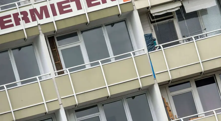 Fassade eines Mehrfamilienhauses mit der Aufschrift "ERMIETEN". Hier könnte man sich über den Mietspiegel Steinhagen informieren.