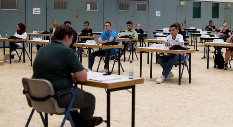 Jugendliche sitzen an Tischen in einer Halle, bereit für eine Sitzung des Jugendparlaments Bottrop.