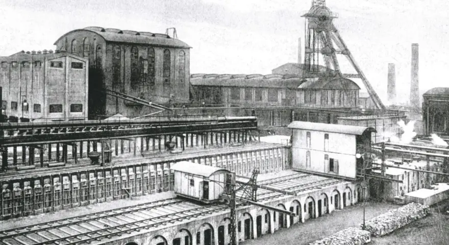Industriekomplex Zeche Recklinghausen Hochlarmark mit Förderturm, Gebäuden und Bahngleisen.