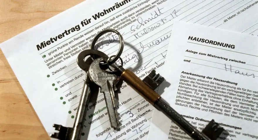 Schlüssel und Mietvertrag für Wohnräume liegen bereit, um den Mietvertrag zu unterschreiben.