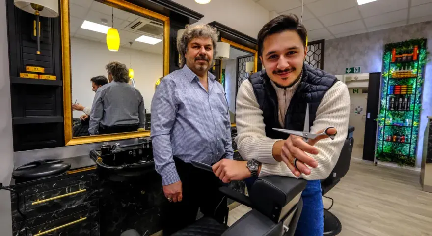 Zwei Herren in einem modernen Salon, bereit für einen Haarschnitt. Der Salon "Schnittkaue Recklinghausen" bietet stilvolle Atmosphäre und professionelle Pflege.