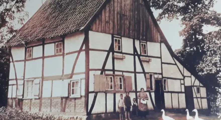 Fachwerkhaus in Lohburg, Waltrop, mit Familie und Gänsen vor dem Haus.