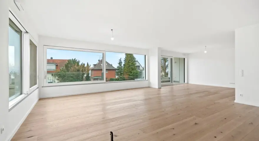 Helles, geräumiges Wohnzimmer mit großen Fenstern und Holzboden. Ideal, wenn Sie ein Mehrfamilienhaus verkaufen möchten.