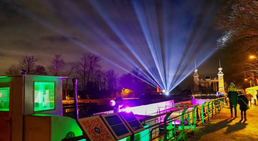Lichterzauber am weihnachtsmarkt schiffshebewerk henrichenburg. Strahlende Lichtkegel erhellen den Nachthimmel über dem beleuchteten Schiffshebewerk.