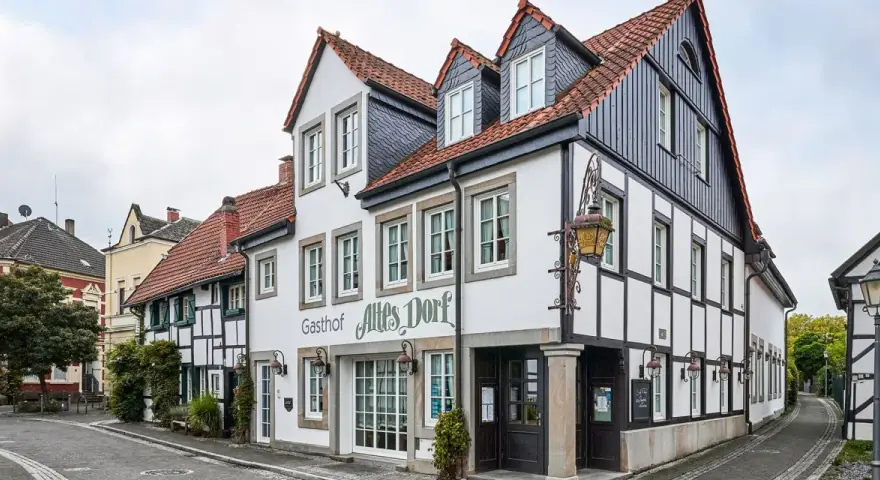 Fachwerkhäuser säumen eine Gasse im Dorf Westerholt. Das Gasthof "Altes Dorf" ist gut erkennbar.