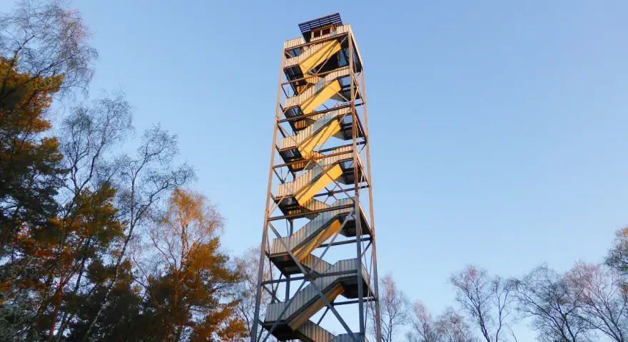 Der feuerwachturm Hohe Mark ragt mit seinen gewendelten Treppen in den blauen Himmel. Umgeben von kahlen Bäumen, verspricht er eine weite Aussicht.