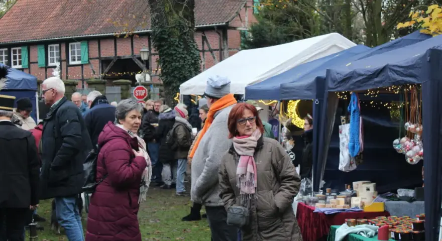 Besucher genießen den Herten Weihnachtsmarkt mit Ständen, Lichtern und festlicher Atmosphäre.