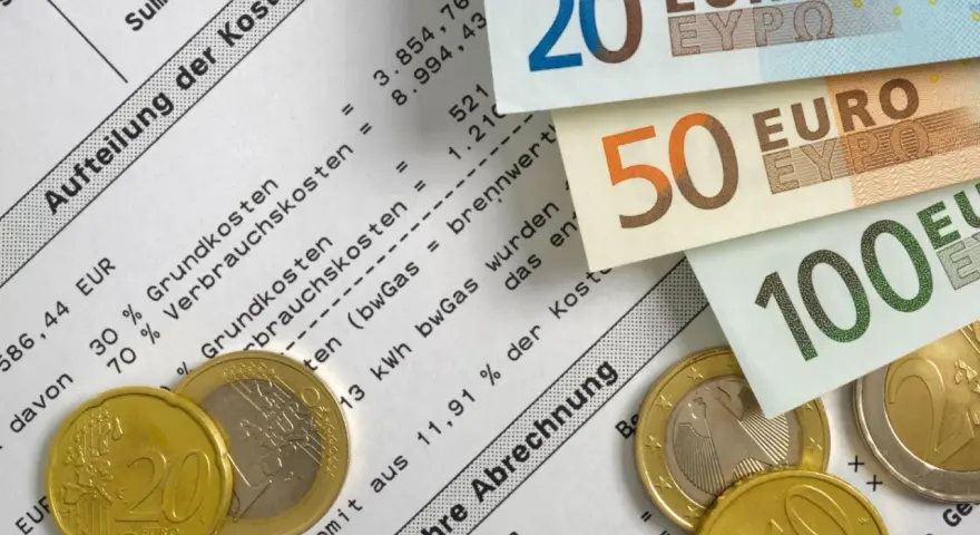 Euro-Scheine und Münzen liegen auf einer Nebenkostenabrechnung. Die Aufteilung der Kosten zeigt die Bedeutung von Mieterrechten bei der Abrechnung.