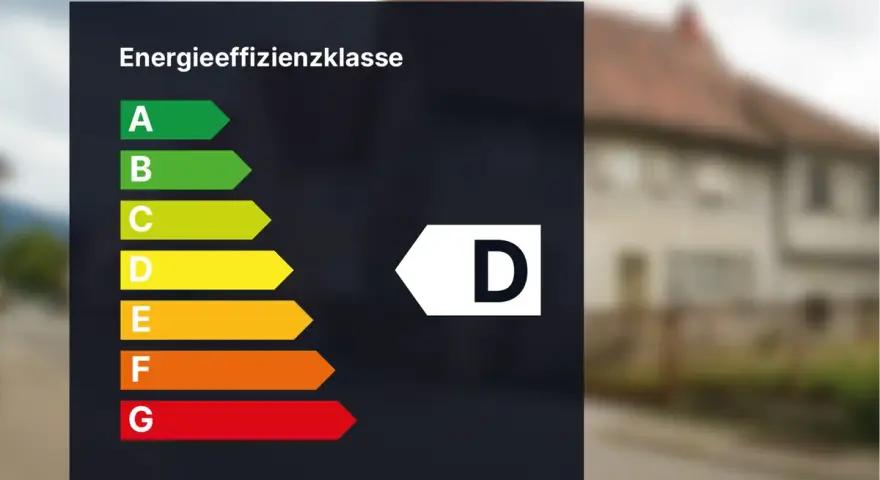 Energieeffizienzklasse D auf einem dunklen Hintergrund. Das Haus im Hintergrund hat eine braune Ziegeldach.