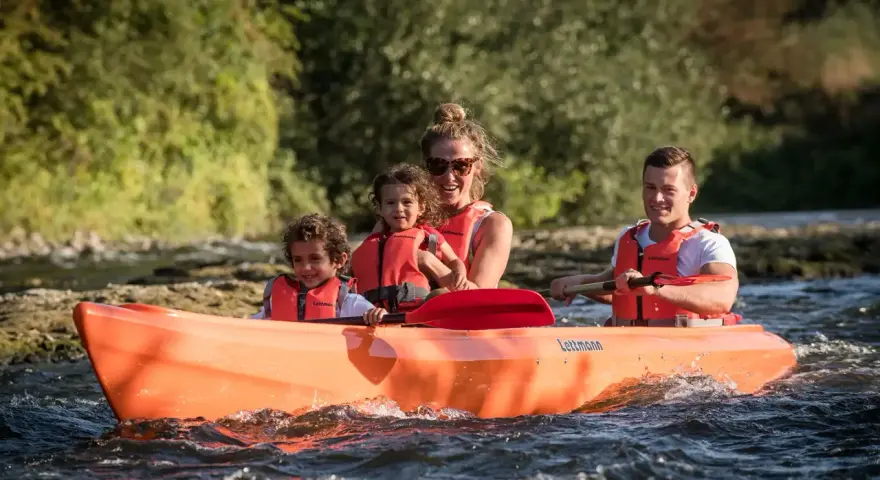 Familie genießt eine Fahrt im Kanu auf der Lippe, Kinder und Eltern mit Schwimmwesten.
