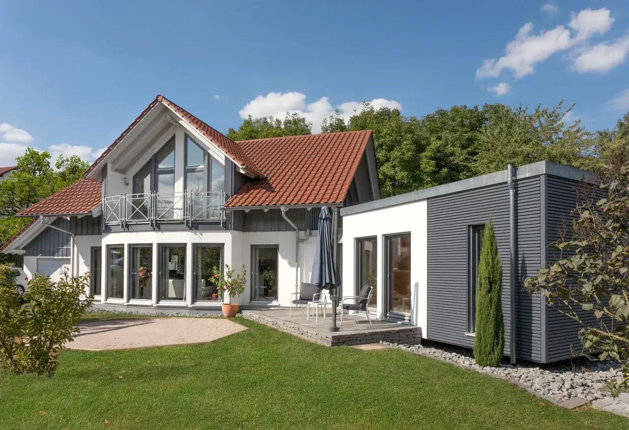 Modernes Haus mit einem tiny house als anbau. Ein Balkon, Terrasse und Garten laden zum Verweilen ein.