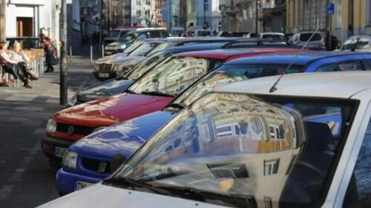 Autos parken in einer Reihe im Frankenberger Viertel Aachen. Im Vordergrund spiegelt sich die Fassade eines Geb&auml;udes in der Windschutzscheibe.