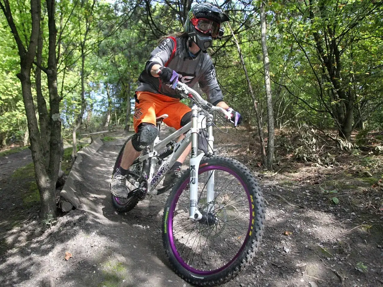 Mountainbikerin f&auml;hrt auf der halde Hoppenbruch durch den Wald, tr&auml;gt Helm und Maske.