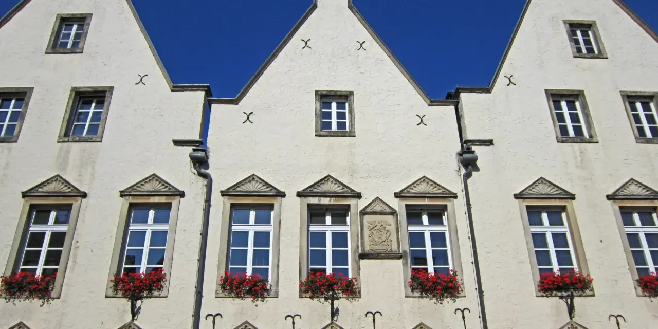 Fassade mit vielen Fenstern und roten Blumenkästen in Haltern am See.