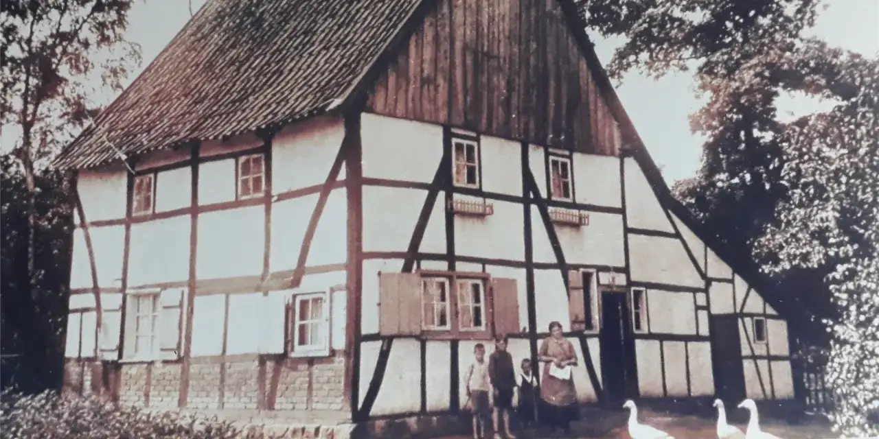 Fachwerkhaus in Lohburg, Waltrop, mit Familie und G&auml;nsen vor dem Eingang.