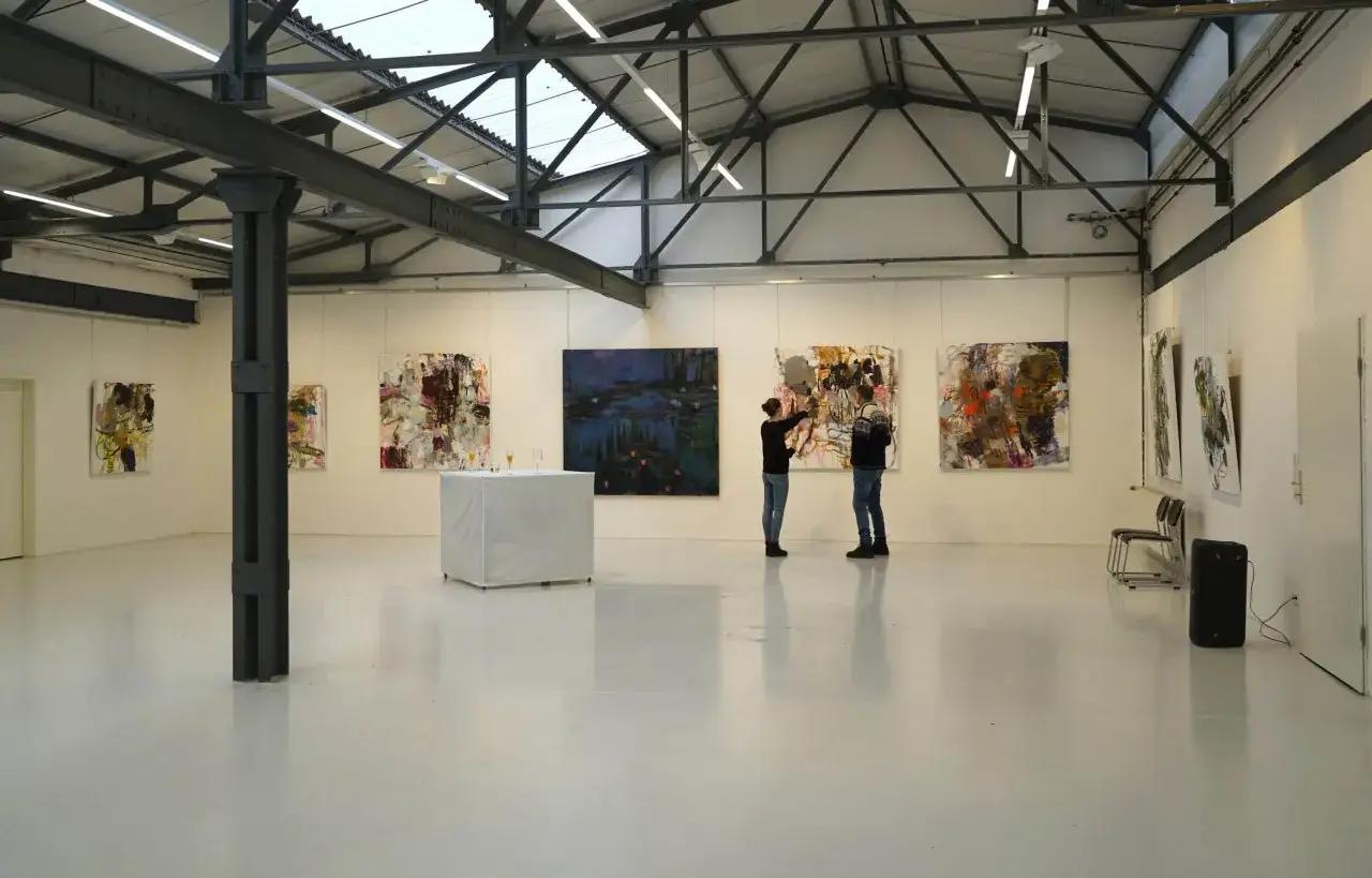 Zwei Besucher betrachten abstrakte Gem&auml;lde in der Kunsthalle Burkamp.