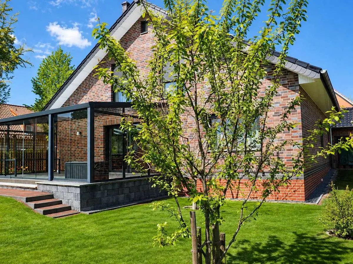 Modernes Haus mit Glasanbau und Garten. Ein Blick auf die Immobilie in Herford, die die aktuellen Immobilienpreise widerspiegelt.