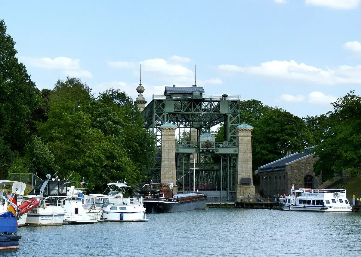 Schiffe liegen am Ufer des Dortmund-Ems-Kanals vor einem historischen Schiffshebewerk.