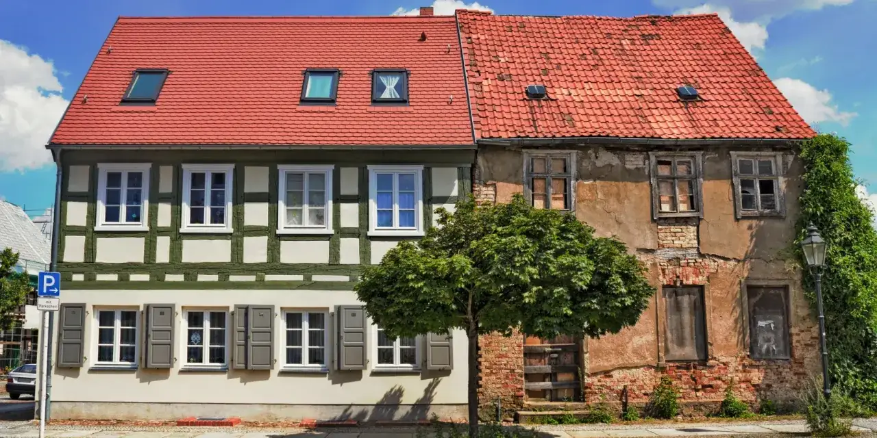Kontrast zwischen renoviertem Fachwerkhaus und verfallenem Nachbarhaus. Die alten Haus renovieren Kosten sind hier deutlich sichtbar.