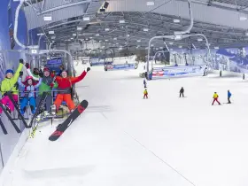Familie genießt eine Fahrt mit dem Sessellift in der Bottroper Skihalle, bereit für den Wintersport.