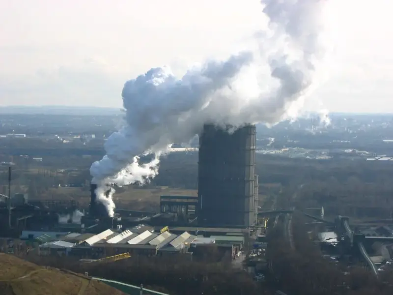 Rauch steigt aus dem hohen Turm der Kokerei Bottrop auf. Die Schließung dieser Industrieanlage markiert das Ende einer Ära.