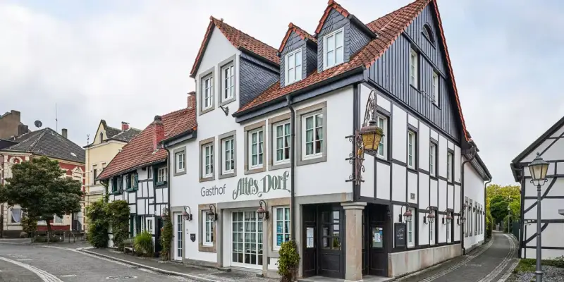 Fachwerkhäuser säumen eine Gasse im Dorf Westerholt. Das Gasthof "Altes Dorf" ist gut erkennbar.